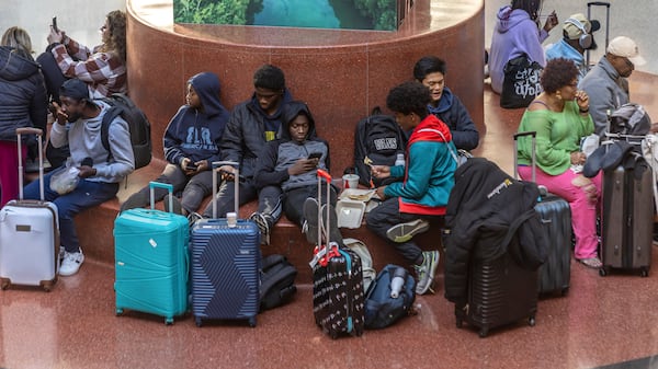 Travelers wait at Hartsfield-Jackson International Airport, Friday, Nov. 22, 2024, in Atlanta, as the Thanksgiving travel season kicks off. (John Spink/Atlanta Journal-Constitution via AP)