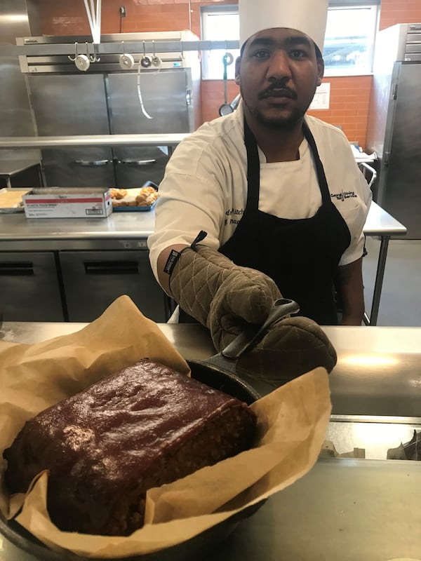 Deandrae Kitchen, chef manager of dining services at Georgia Tech’s West Village, holds a pan of vegan meatloaf prepared with a plant-based meat alternative from Impossible Foods. LIGAYA FIGUERAS / LFIGUERAS@AJC.COM