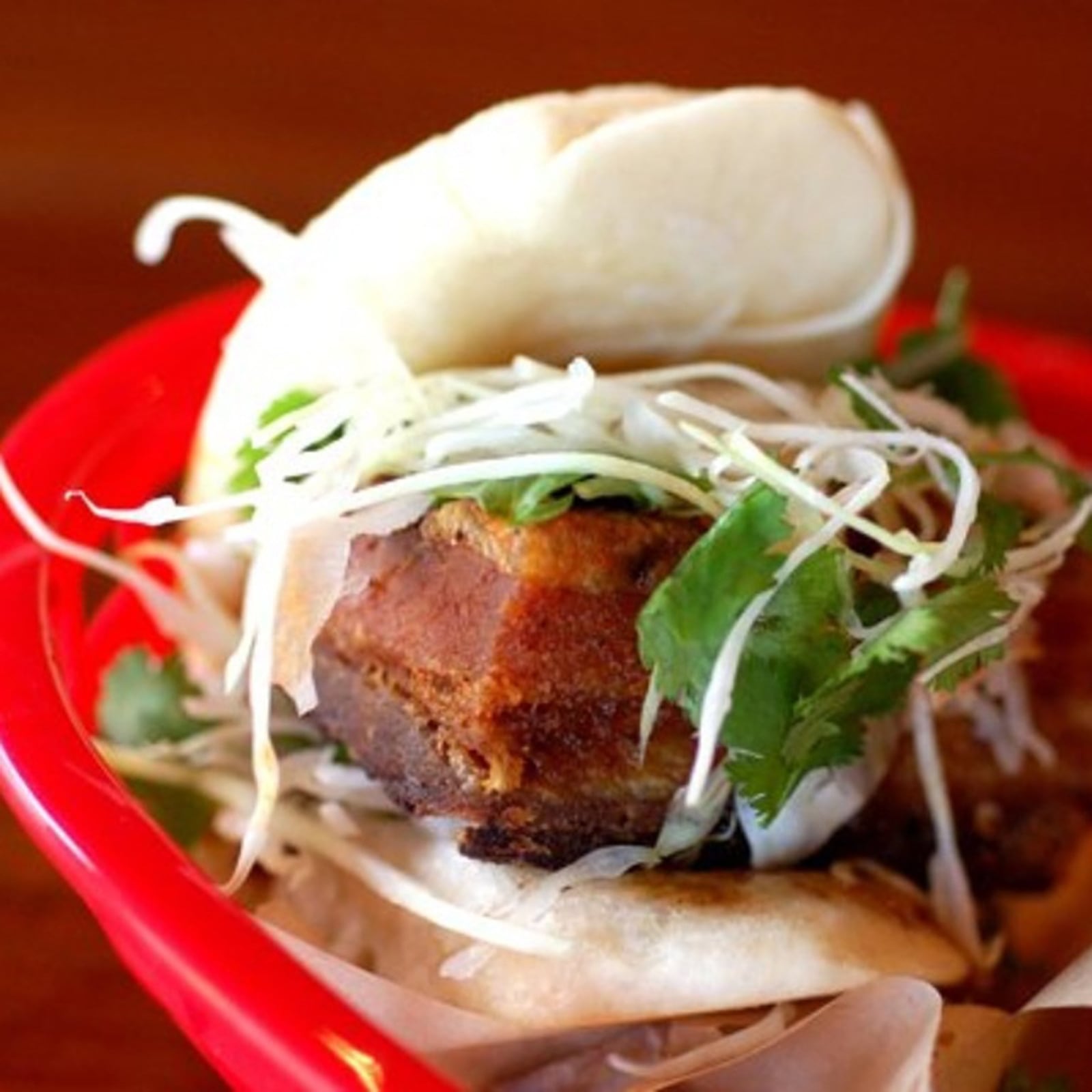 Latin-meets-Asian in the steamed pork belly bun with crispy smoked piloncillo pork belly, sambal, spicy tamarind sauce and cilantro slaw. (El Super Pan)