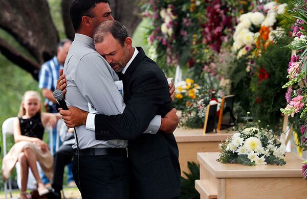 Men embrace Thursday at the funeral of three family members in La Mora, Sonora state, Mexico.