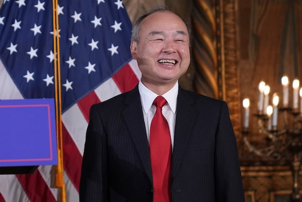 SoftBank Group CEO Masayoshi Son smiles as he listens to President-elect Donald Trump during a news conference at Mar-a-Lago, Monday, Dec. 16, 2024, in Palm Beach, Fla. (AP Photo/Evan Vucci)