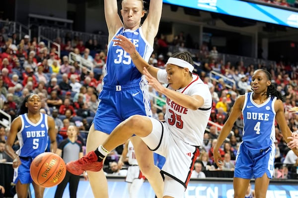 NC State guard Zoe Brooks, center, loses the ball as she drives between Duke forward Toby Fournier, left, and Duke guard Jadyn Donovan, back, during an NCAA college basketball game in the championship of the Atlantic Coast Conference tournament Greensboro, N.C., Sunday, March 9, 2025. (AP Photo/Chuck Burton)