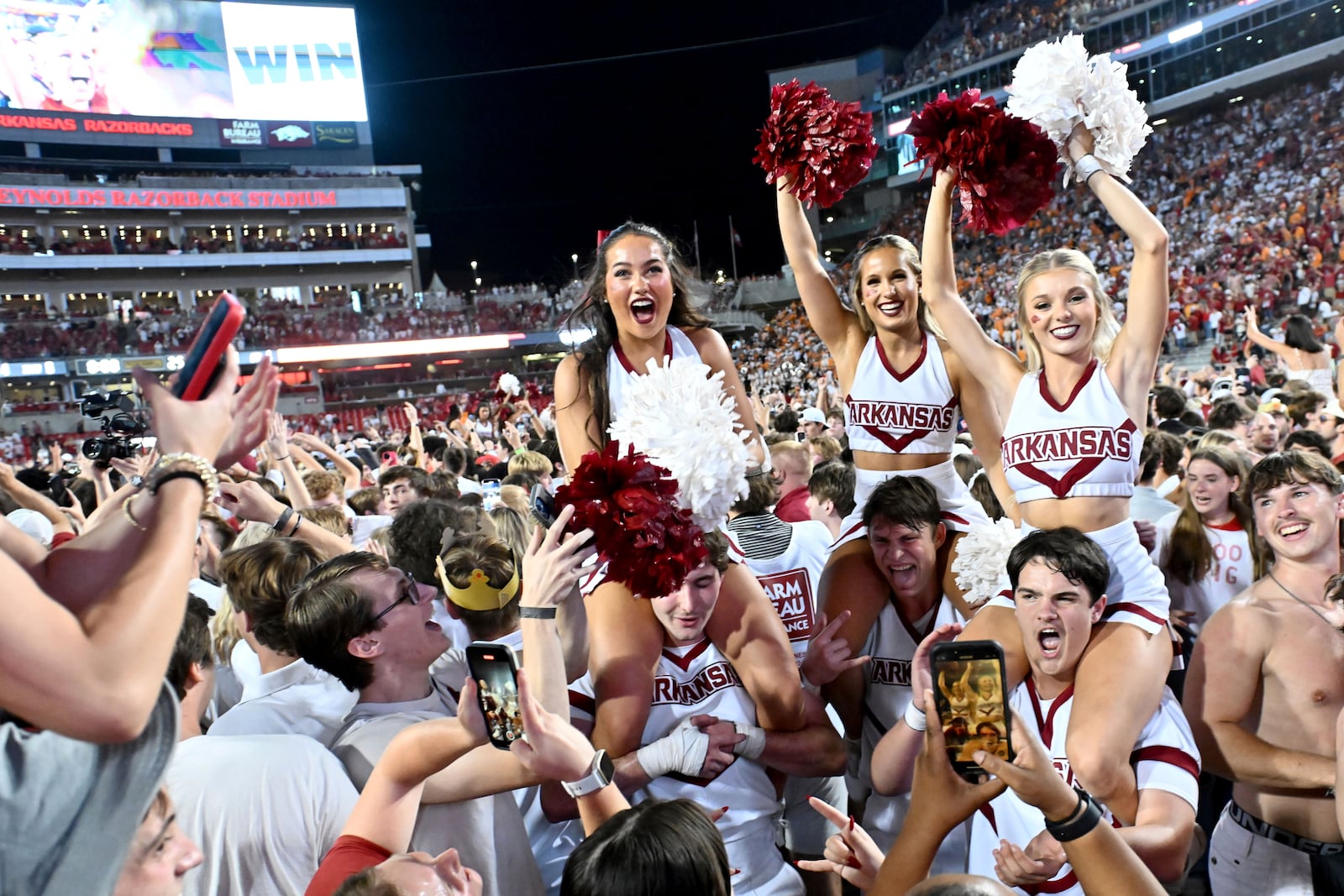 Arkansas cheerleaders and fans celebrate after Arkansas upsets Tennessee 19-14 during an NCAA college football game, Saturday, Oct. 5, 2024, in Fayetteville, Ark. (AP Photo/Michael Woods)