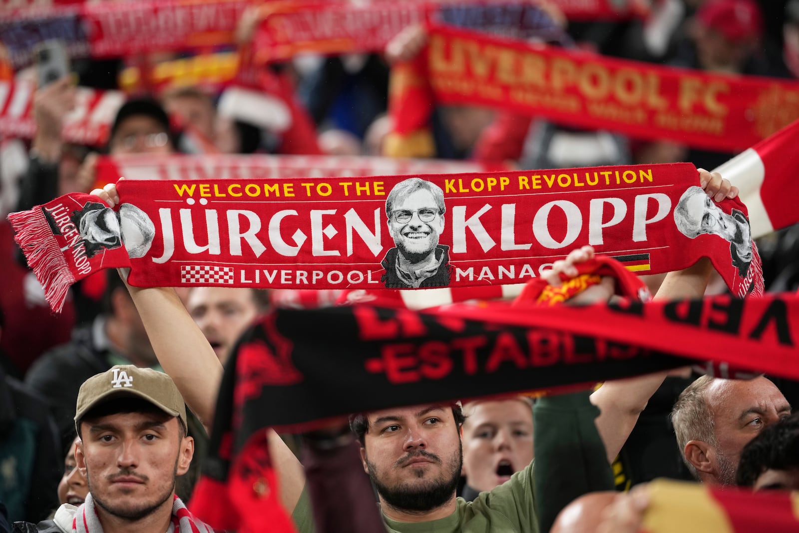 A Liverpool fan holds up a scarf with a picture of former team coach Juergen Klopp, during the English League Cup soccer match between Liverpool and West Ham United at Anfield Stadium, Liverpool, England, Wednesday, Sept. 25, 2024. (AP Photo/Jon Super)