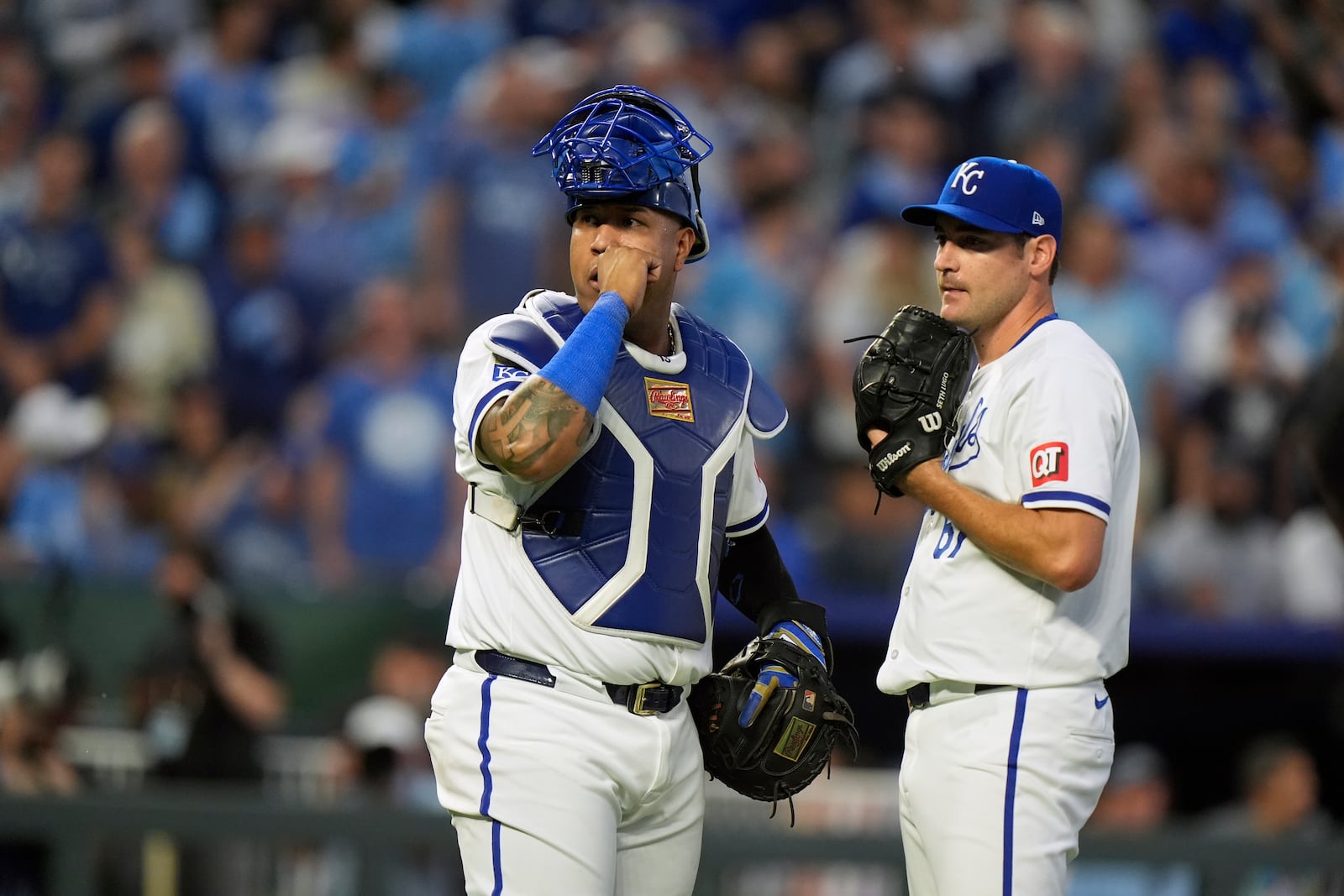 Kansas City Royals catcher Salvador Perez, left, and starting pitcher Seth Lugo pause as a play undergoes video review during the third inning in Game 3 of an American League Division baseball playoff series against the New York Yankees Wednesday, Oct. 9, 2024, in Kansas City, Mo. (AP Photo/Charlie Riedel)