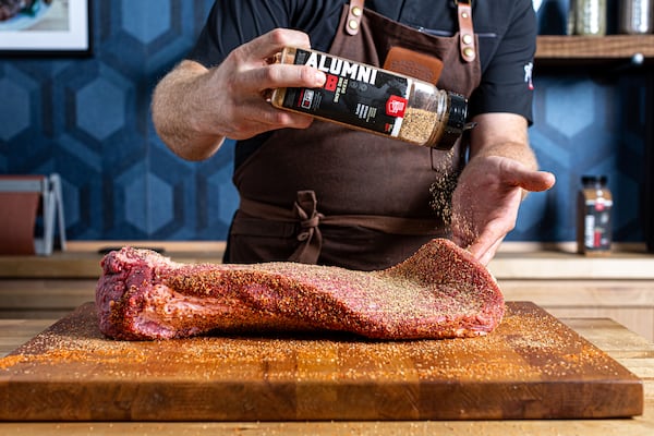 A Backyard Pitmasters instructor seasons brisket during a class. (Courtesy of Backyard Pitmasters)