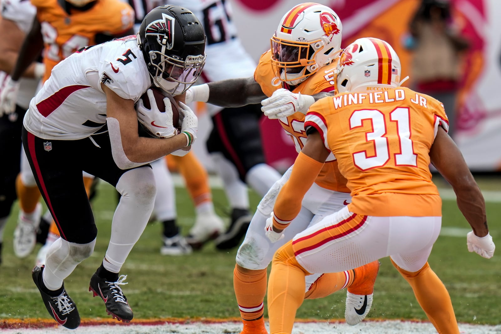 Atlanta Falcons wide receiver Drake London (5) is stopped by Tampa Bay Buccaneers linebacker K.J. Britt (52) and safety Antoine Winfield Jr. (31) during the first half of an NFL football game, Sunday, Oct. 27, 2024, in Tampa. (AP Photo/Chris O'Meara)