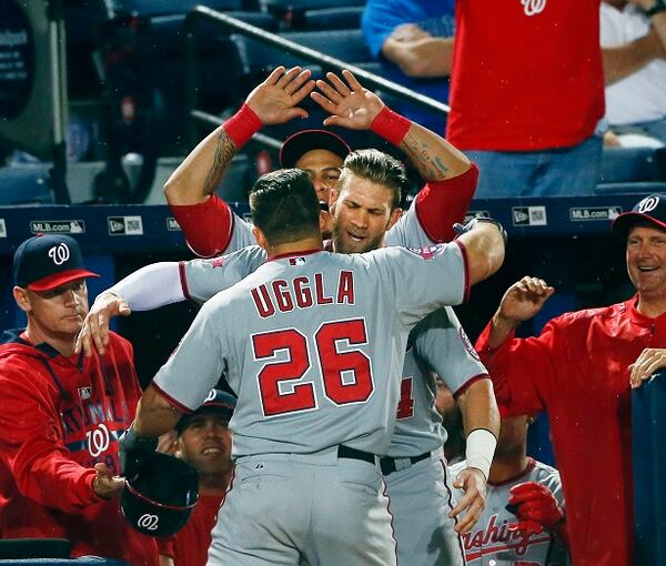 Washington Nationals' Dan Uggla (26) is embraced by teammate Bryce Harper after hitting a three-run home run in the ninth inning of a baseball game against the Atlanta Braves Tuesday, April 28, 2015, in Atlanta. Washington won 13-12. (AP Photo/John Bazemore) You can't write this stuff, folks. (AP Photo/John Bazemore)