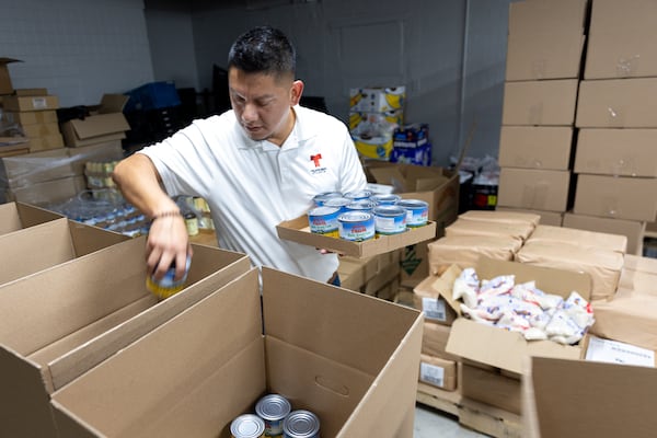 Volunteer Juan Flores, a media executive at Telemundo Atlanta, packed boxes at Jonesboro Community Food Center in Jonesboro on Monday, November 18, 2024. The Atlanta Community Food Bank is hosted its annual Thanksgiving Dish, where families were able to get Thanksgiving-themed food boxes along with other groceries. (Arvin Temkar / AJC)