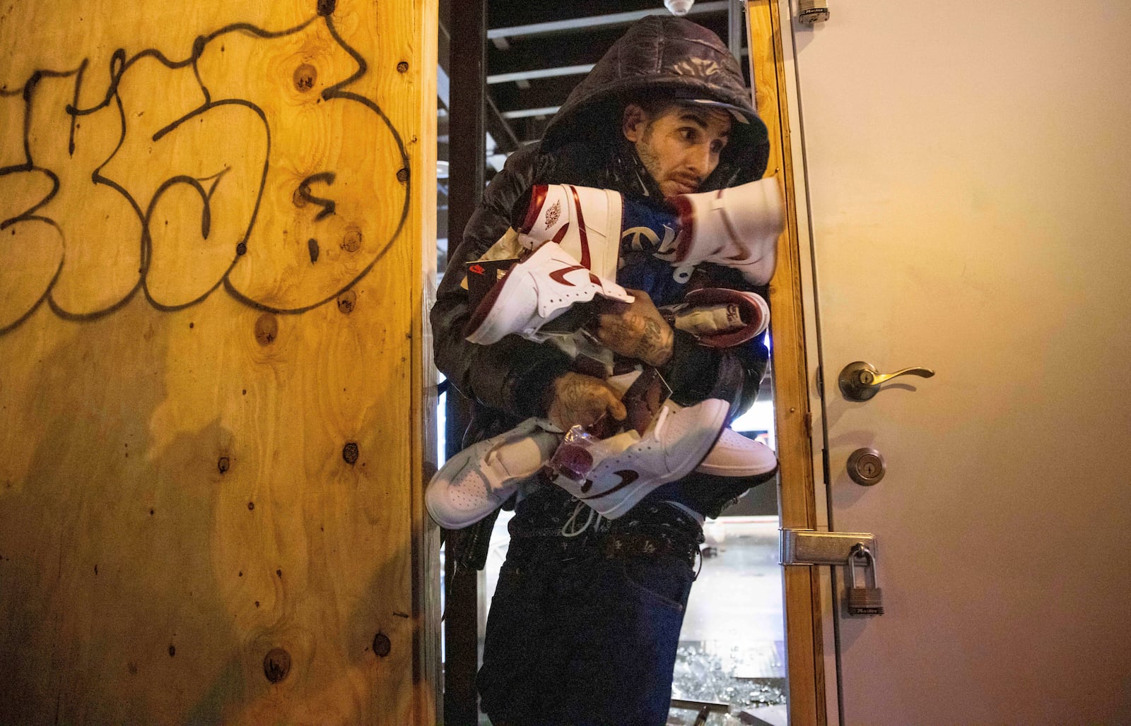 A person carries out items from a ransacked Nike store after the Los Angeles Dodgers defeated the New York Yankees to win the baseball World Series Wednesday, Oct. 30, 2024, in Los Angeles. (AP Photo/Ethan Swope)