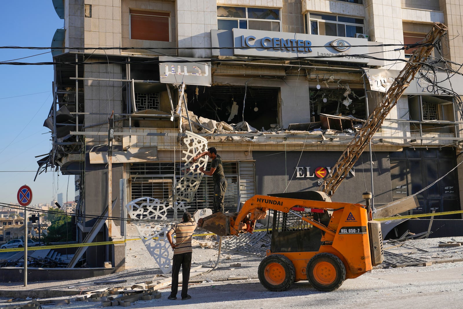 Rescue workers use a skid loader to remove rubble at the site of an Israeli airstrike that hit several branches of the Hezbollah-run al-Qard al-Hassan in Dahiyeh, Beirut, Lebanon, Monday, Oct. 21, 2024. (AP Photo/Hassan Ammar)