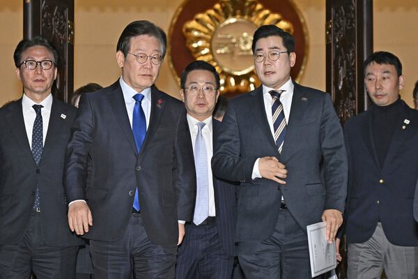 South Korea's main opposition Democratic Party leader Lee Jae-myung, front left, and its floor leader Park Chan-dae, front right, leave a room at the National Assembly in Seoul after South Korea’s parliament voted to impeach President Yoon Suk Yeol Saturday, Dec. 14, 2024. (Kyodo News via AP)