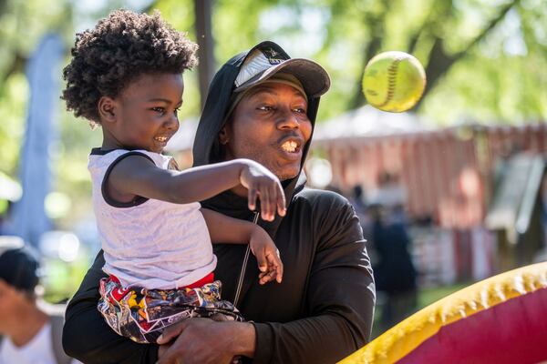 Jamaal Summerson and his son Elijah, 3, play one of the inflatable games at the second Taste Of Mableton Festival Saturday, April 15, 2023.  (Steve Schaefer/steve.schaefer@ajc.com)