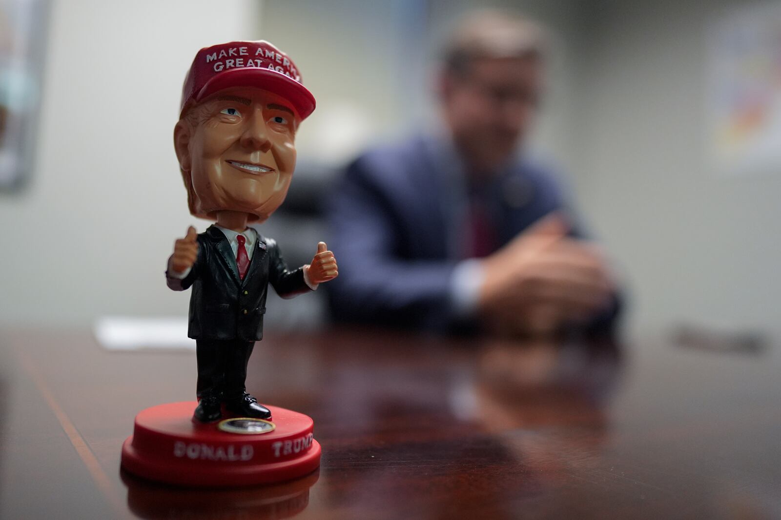 A bobblehead of Republican presidential nominee former President Donald Trump sits on the desk as Speaker of the House Mike Johnson, R-La., speaks during an interview with The Associated Press at the Lucas County Republican Party headquarters in Holland, Ohio, Saturday, Oct. 26, 2024. (AP Photo/Carolyn Kaster)