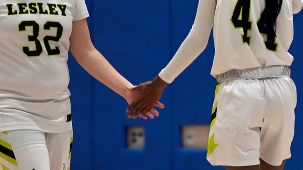 Lesley College basketball player Baileigh Sinaman-Daniel (44) low-fives teammate Aaliyah Wilburn prior to a game, Tuesday, Feb. 11, 2025, in Lexington, Mass. (AP Photo/Charles Krupa)