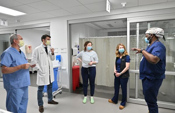 Dr. Clark Kensinger, second from left, confers with his team members (from left): James Waters, Respiratory Therapist, Sarah Gordon, RN, 
Katie Meliezer, RN, and Terrence Brock, Contract Transplant Coordinator, at the Organ Recovery Center at Piedmont Atlanta Hospital on Thursday, March 3, 2022. The new organ recovery center opened a year ago with its own dedicated care team of nurses and doctors, and uses innovative organ preservation techniques. (Hyosub Shin / Hyosub.Shin@ajc.com)

