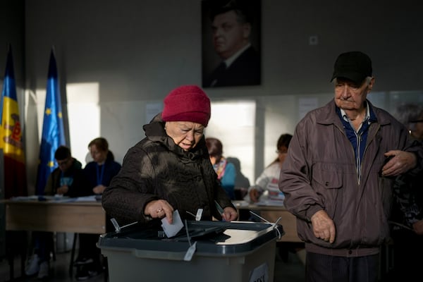 A woman prepares to cast her vote during a presidential election runoff, in Chisinau, Moldova, Sunday, Nov. 3, 2024. (AP Photo/Vadim Ghirda)