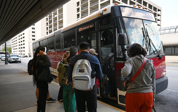 Customers climb aboard a Gwinnett County Transit bus at Atlanta's Civic Center MARTA station.