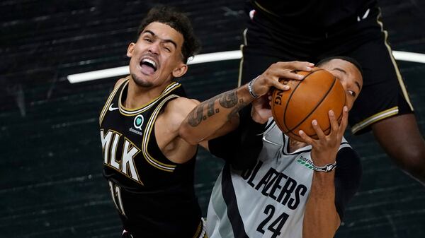 Hawks guard Trae Young (11) and Portland Trail Blazers forward Norman Powell (24) battle for a rebound in the second half Monday, May 3, 2021, in Atlanta. (John Bazemore/AP)