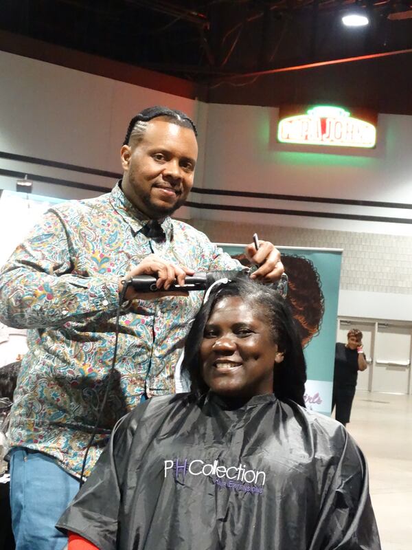 Chris Hernandez, a hairstylist, gives Wendy McClain of Florence, S.C. a curling. CREDIT: Rodney Ho/ rho@ajc.com