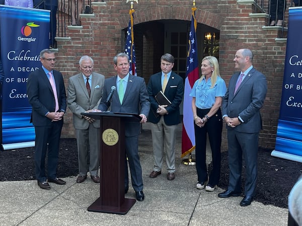 Gov. Brian Kemp touts a ranking from Area Development Magazine. He's joined by Chris Cummiskey, former Gov. Nathan Deal, Pat Wilson, first lady Marty Kemp and Georgia Attorney General Chris Carr. (Greg Bluestein/AJC)