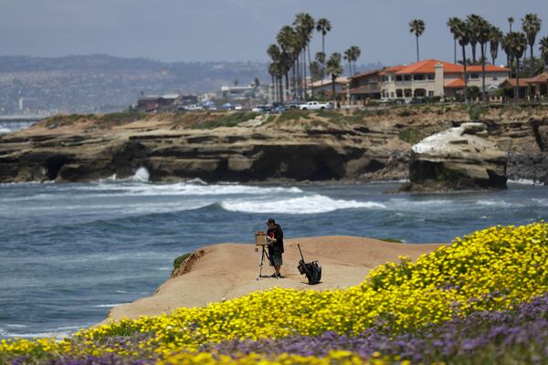 Brett Berndes paints at Sunset Cliffs Natural Park, after portions of the park opened Tuesday in San Diego. The city opened some neighborhood parks for individual use Tuesday, though city beaches remain closed to help stop the spread of the new coronavirus. 