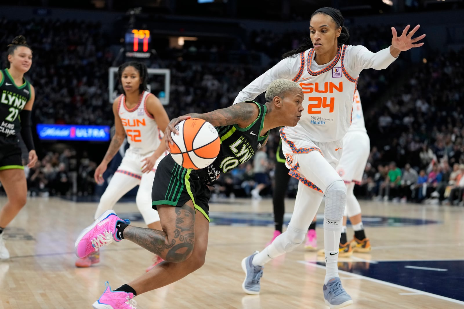 Minnesota Lynx guard Courtney Williams (10) works toward the basket as Connecticut Sun forward DeWanna Bonner (24) defends during the second half of Game 5 of a WNBA basketball semifinals, Tuesday, Oct. 8, 2024, in Minneapolis. (AP Photo/Abbie Parr)