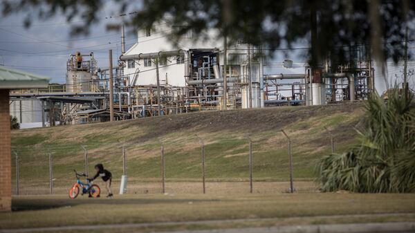 A factory used by the chemical manufacturer Pinova looms over public housing residences in the Urbana-Perry Park neighborhood of Brunswick. A fire in 2023 destroyed a portion of the plant and the company announced last year that it is closing the facility permanently. (AJC Photo/Stephen B. Morton)