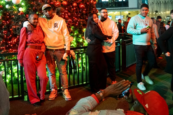 People pose for photos following the Christmas tree lighting at Atlantic Station in Atlanta on Saturday, Nov. 23, 2024.   Ben Gray for the Atlanta Journal-Constitution