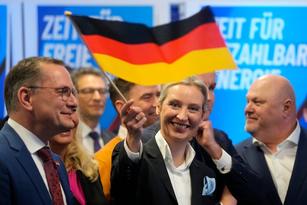 Leader of far right AfD Alice Weidel waves a German flag at the AfD party headquarters in Berlin, Germany, Sunday, Feb. 23, 2025, after the German national election. (AP Photo/Michael Probst)