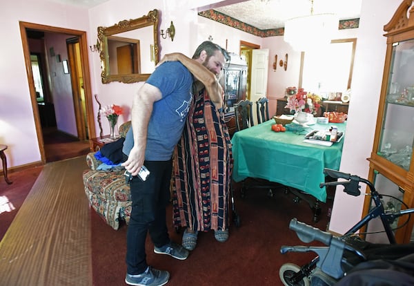 Justin Schaeffer gets a hug from Annie Williams as he visits Williams' home in Kirkwood. (Hyosub Shin / Hyosub.Shin@ajc.com)