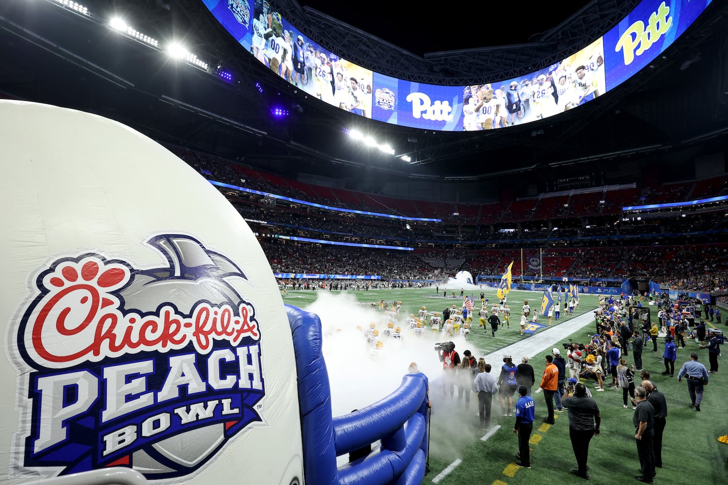 The Pittsburgh Panthers run on the field before the Chick-fil-A Peach Bowl before their game against the Michigan State Spartans at Mercedes-Benz Stadium in Atlanta, Thursday, December 30, 2021. JASON GETZ FOR THE ATLANTA JOURNAL-CONSTITUTION