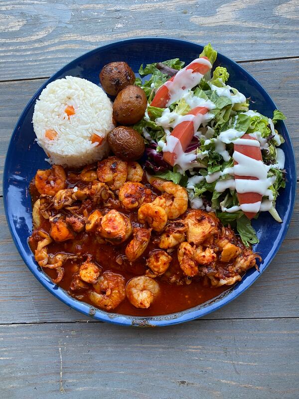 The filete del capi at El Capitan has grilled sea bass topped with shrimp in adobo sauce and comes with rice, new potatoes and a lettuce salad. Ligaya Figueras/ligaya.figueras@ajc.com