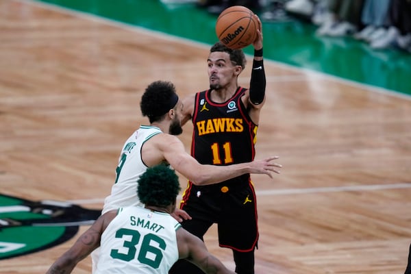 Atlanta Hawks guard Trae Young (11) passes the ball while pressured by Boston Celtics guard Derrick White during the second half of Game 2 in the first round of the NBA basketball playoffs, Tuesday, April 18, 2023, in Boston. (AP Photo/Charles Krupa)