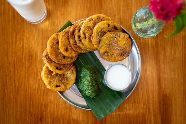 Chai Pani Green Tomato Pakora, crunchy green tomato fritters made with curried chickpea batter, served with mint chutney and sweet yogurt. (Mia Yakel for The Atlanta Journal-Constitution)