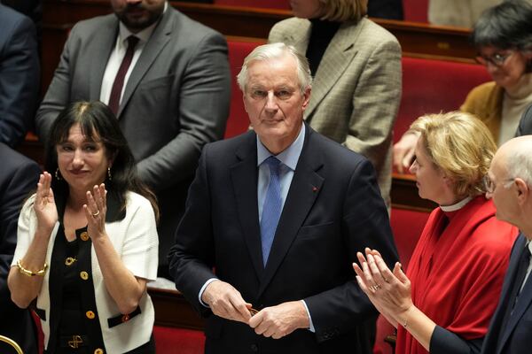 French Prime Minister Michel Barnier gets applause from ministers after addressing the National Assembly prior to a vote on a no-confidence motion that could bring him down and his cabinet for the first time since 1962, Wednesday, Dec. 4, 2024 in Paris. (AP Photo/Michel Euler)