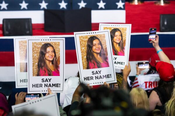 Attendees hold signs bearing a photo of Laken Riley during a rally for former President Donald Trump in Rome, Georgia, on March 9, 2024. (Nicole Craine/The New York Times)
                      