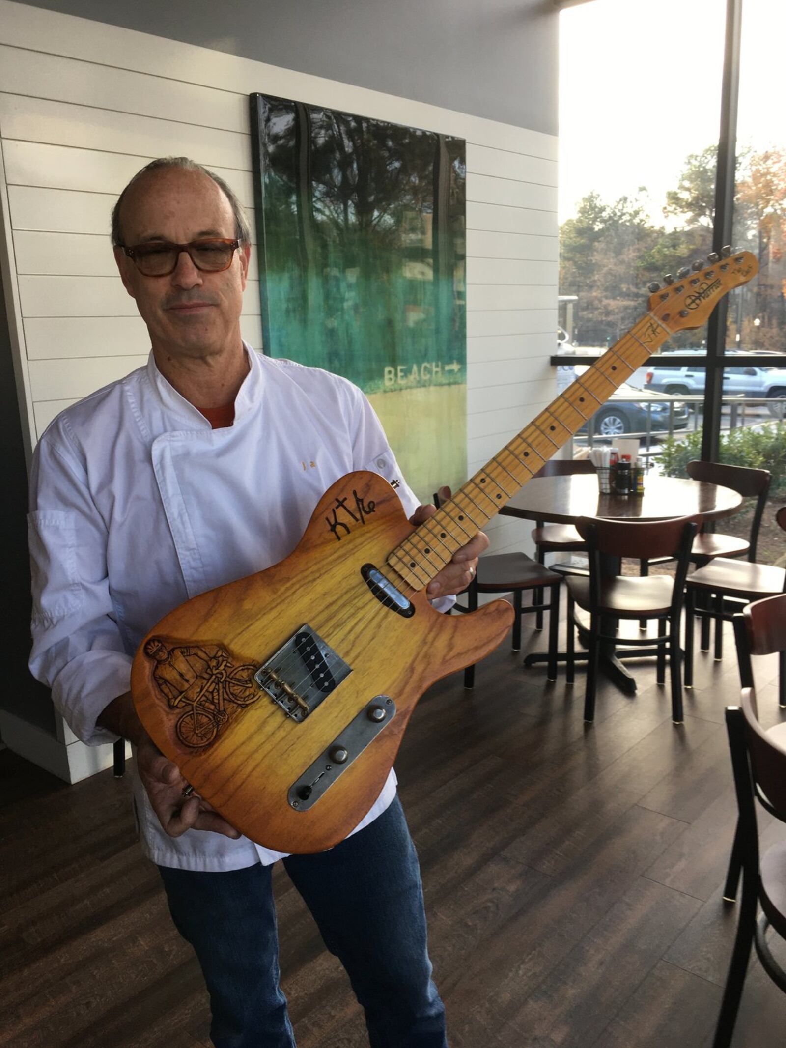 Chef Jamie Adams on the patio at Lagarde showing guests his custom-made guitar. Contributed by Bob Townsend