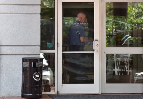 Hotel staff enters Sheraton Atlanta hotel in downtown Atlanta on a recent day. (Hyosub Shin / Hyosub.Shin@ajc.com)