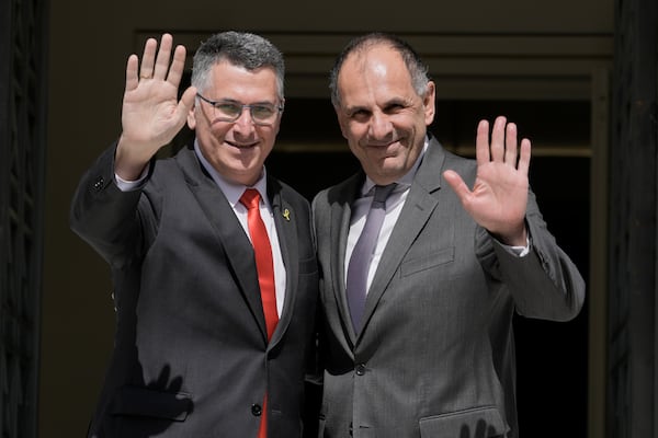 Greece's Foreign Minister Giorgos Gerapetritis, right, and Israel's Foreign Minister Gideon Sa'ar wave to photographers before a trilateral meeting with Cyprus' Foreign Minister on energy cooperation in Athens, Greece, Thursday, March 13, 2025.(AP Photo/Petros Giannakouris)