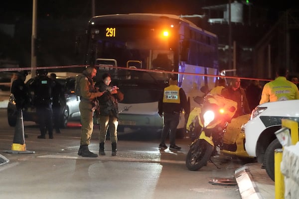 Israeli security forces work at the scene of a shooting attack on a bus near the West Bank town of Beit Jala, early Thursday, Dec. 12, 2024. (AP Photo/Mahmoud Illean)