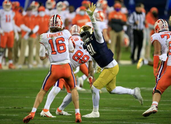 Notre Dame defensive lineman Adetokunbo Ogundeji (91) pressures Clemson quarterback Trevor Lawrence (16) during the second half of the Atlantic Coast Conference championship NCAA college football game, Saturday, Dec. 19, 2020, in Charlotte, N.C. (AP Photo/Brian Blanco)