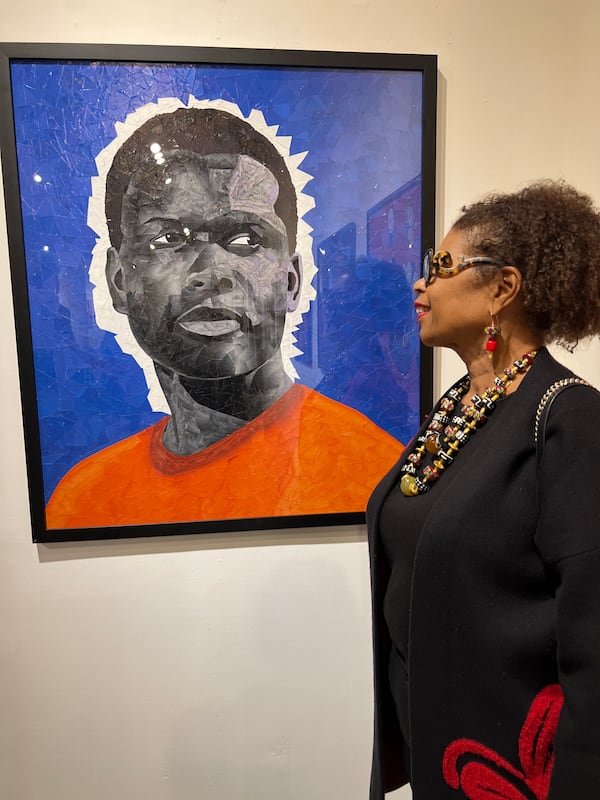 Beverly Henderson, daughter of Sidney Poitier, stands next to a painting of her father by artist Jim Hill on February 9, 2023, at Mason Fine Art in Atlanta.