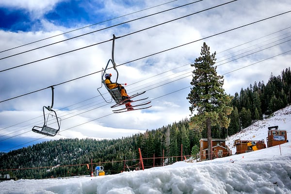 Skiers ride a lift to the slopes after a fresh snowfall at the Palisades Tahoe Ski Resort in Olympic Valley, Calif. for opening day of the ski season on Friday, Nov. 22, 2024. (AP Photo/Brooke Hess-Homeier)