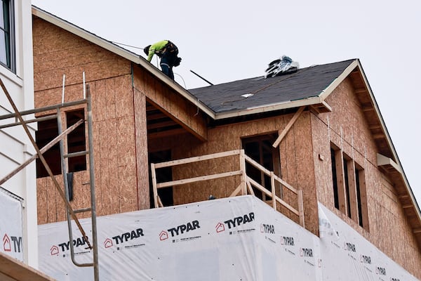 A worker continues construction on a luxury townhouse at Foundry by JW Homes in Alpharetta on Friday, August 19, 2022. (Natrice Miller/AJC)