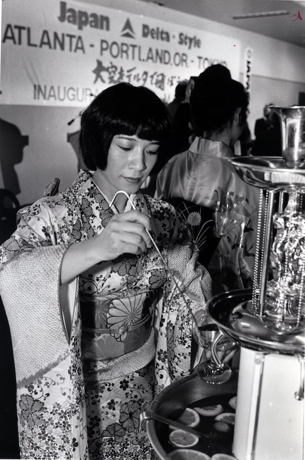 Pouring punch in her native dress, Ruriko Ishii from Japan, serving patrons as Delta's first flight to Japan is celebrated at Hartsfield-Jackson International Airport in 1987. (AJC file photo)