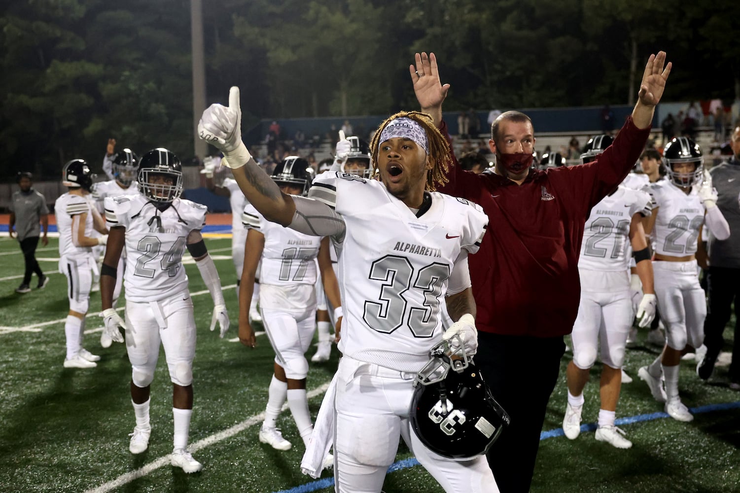 Instead of shaking hands, Alpharetta linebacker Deangleo Reed (33) and teammates wave to Chattahoochee players after Alpharetta won 21-7 at Chattahoochee high school Friday, September 25, 2020 in Johns Creek, Ga.. JASON GETZ FOR THE ATLANTA JOURNAL-CONSTITUTION