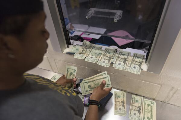 Mary Hooks, co-director of Southerners on New Ground, lays out money at the bonding station to bail out seven mothers from Fulton County Jail on Thursday. (DAVID BARNES / DAVID.BARNES@AJC.COM)