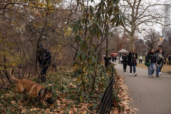 NYPD officers and K-9 dog search around the lake in the Central Park, Monday, Dec. 9, 2024, in New York. (AP Photo/Yuki Iwamura)