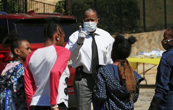 Fulton County District 6 Commissioner Joe Carn talks to kids during the Grab and Go free food and groceries event on Friday, April 17, 2020, at Allen Hills Apartments in Atlanta, which was organized to help families during the coronavirus pandemic. (Christina Matacotta, for The Atlanta Journal-Constitution)